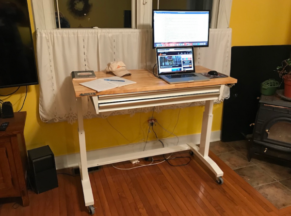 Meja kerja dengan mekanisme penyesuaian tinggi untuk penggunaan berdiri atau duduk